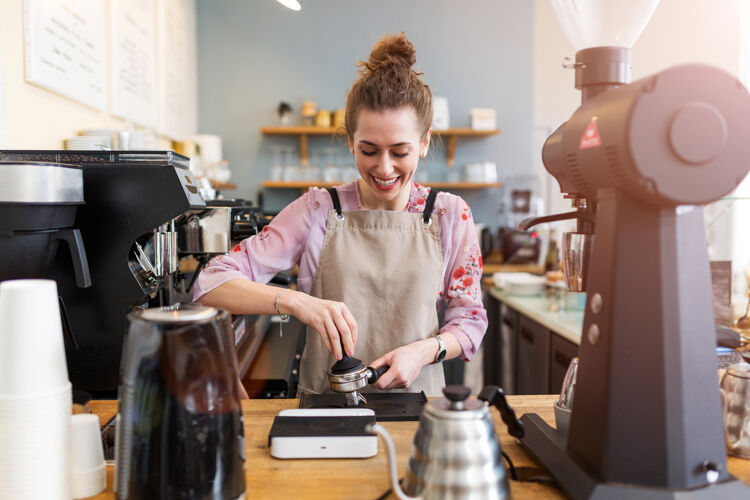vrouw-met-schort-maakt-koffie