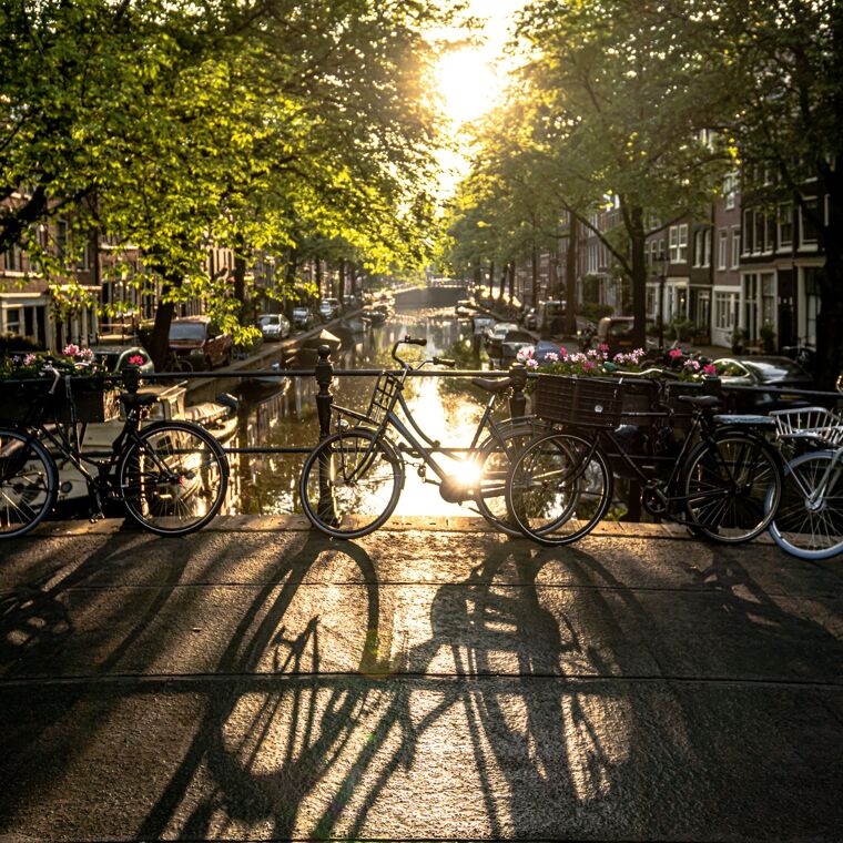 Afbeelding op de Amsterdamse grachten met fietsen tegen de reling. 