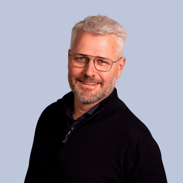 medewerker Chris Kemperman Qredits man in blauw shirt voor grijze achtergrond