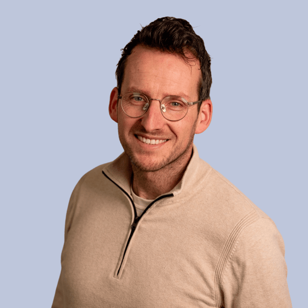 medewerker Qredits Dennis Waalderink man in blauw shirt voor grijze achtergrond