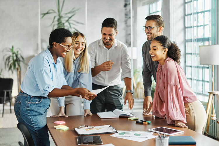 groep-mensen-aan-tafel-kijkend-naar-document