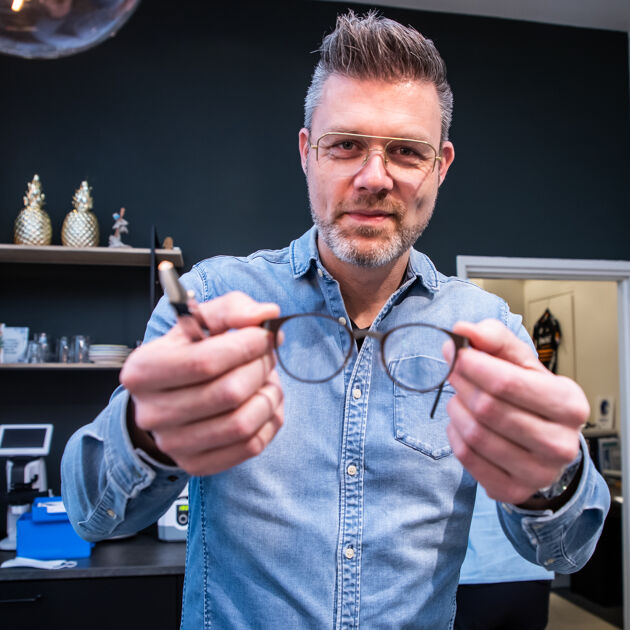 Man heeft een bril vast in zijn handen