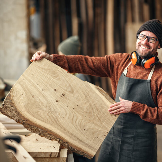 Man met beanie met groot houten blok