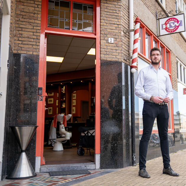 Ondernemer die voor zijn kapperszaak staat