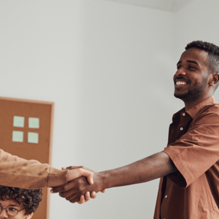Man in bruin shirt schud hand van andere man