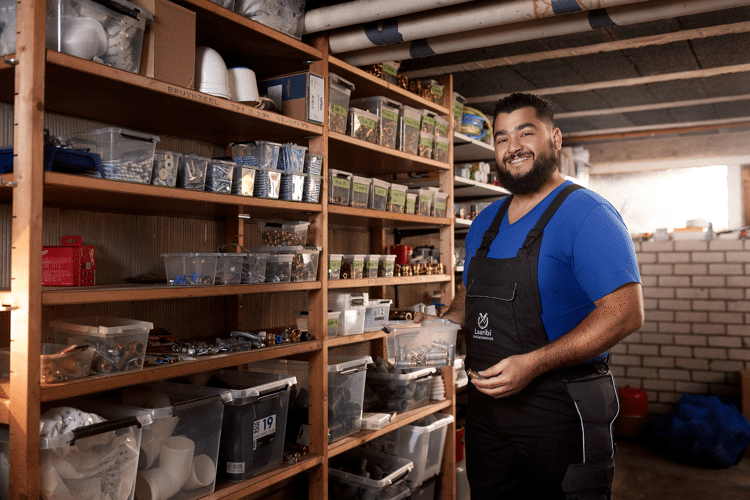 man-staat-in-schuur-met-gereedschap