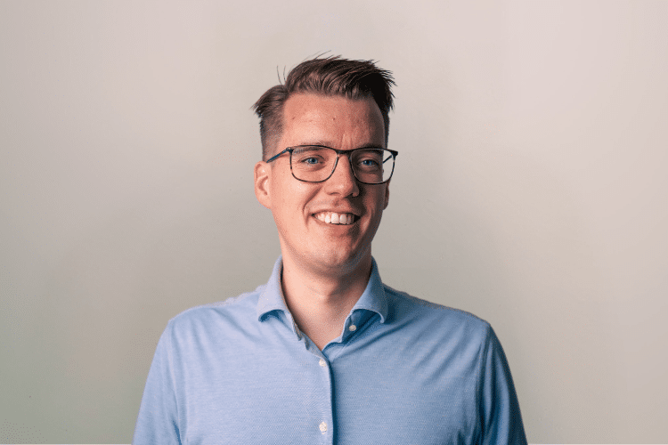 medewerker Qredits Marc Wessels man in blauw shirt voor grijze achtergrond