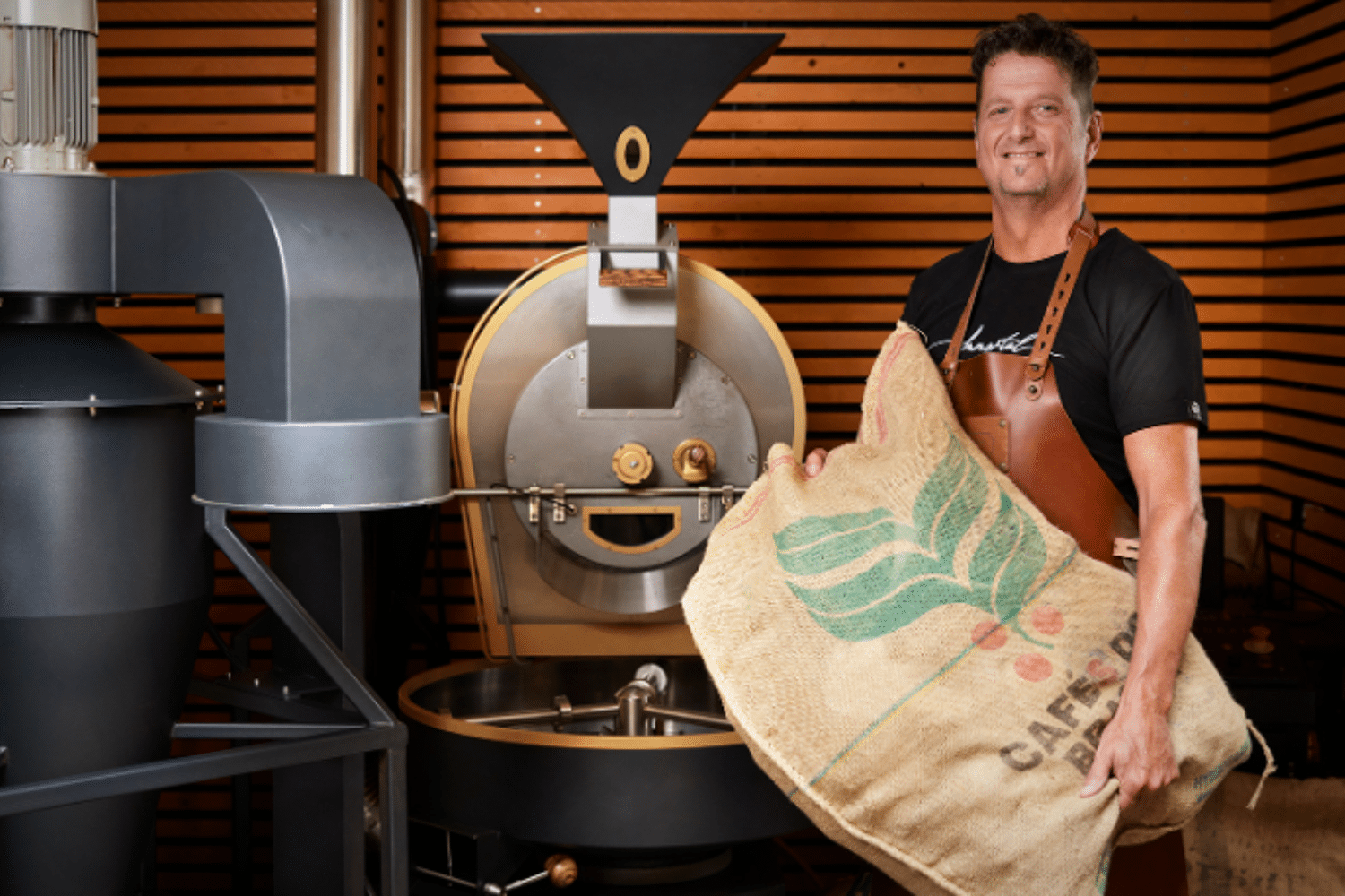 Man staat in koffiebranderij met een zak koffiebonen in zijn hand