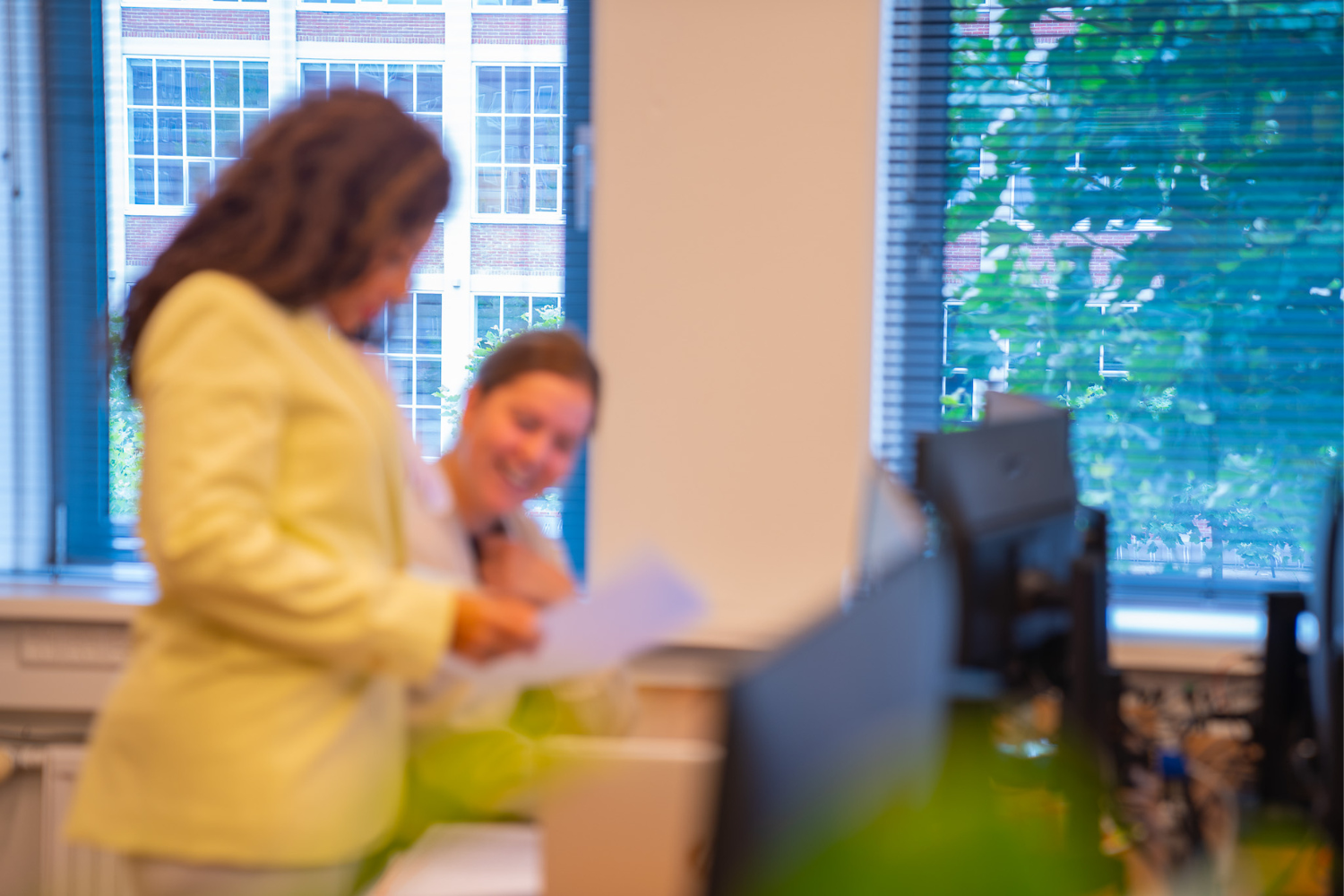 team-kredietondersteuning Twee vrouwen praten op kantoor en zijn wazig