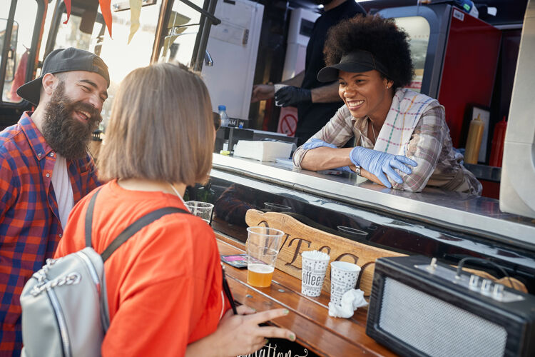 vrouw-in-foodtruck-lacht-naar-klanten