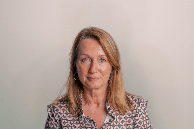 Karin medewerker Qredits vrouw in shirt met patroon voor grijze achtergrond