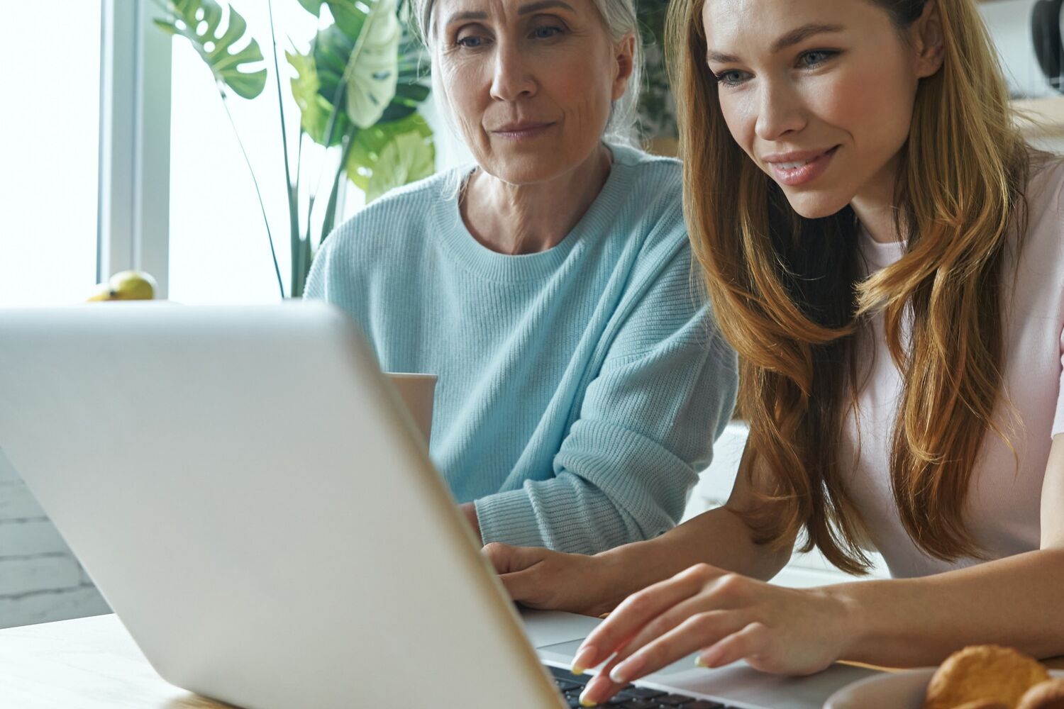 Twee vrouwen kijken geconcentreerd naar een laptop.