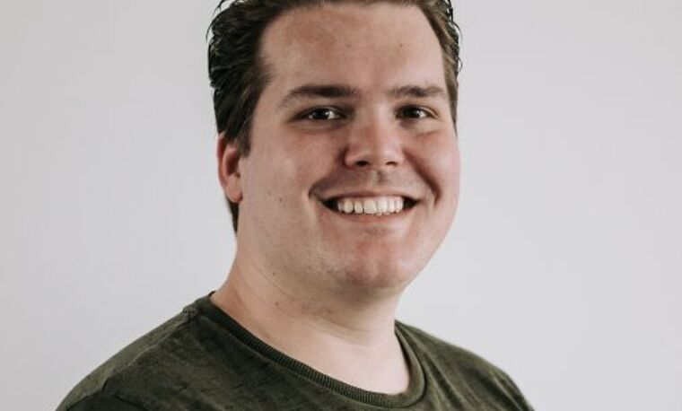 Man in groen shirt lacht naar de camera
