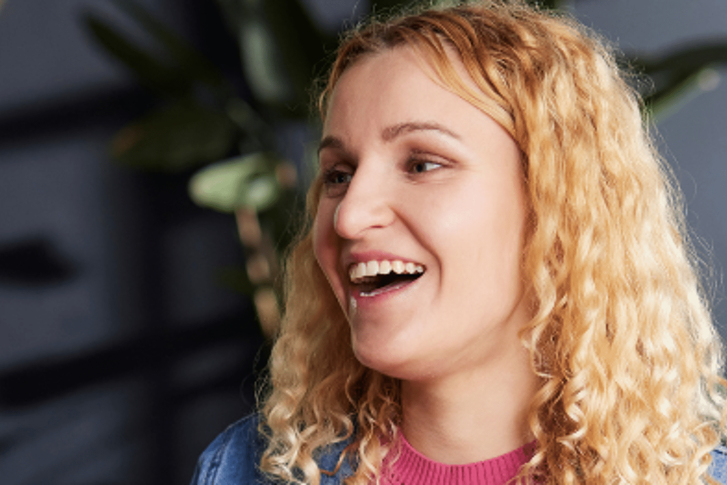 Vrouw in gesprek met man, beide personen lachen. 