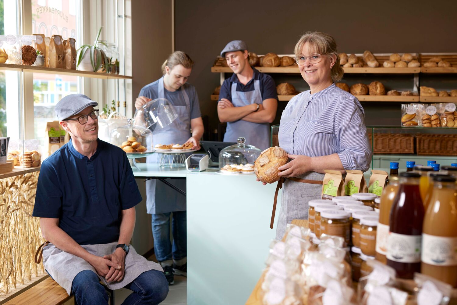 Een team staat in bakkerij en laat vers brood zien Een team staat in bakkerij en laat vers brood zien