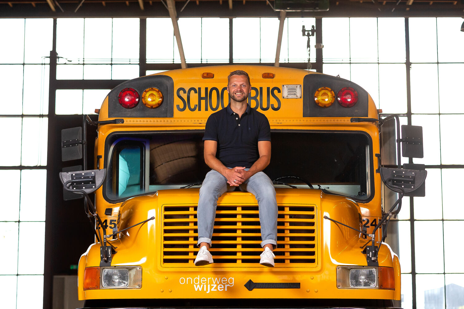 Man zit op een oude Amerikaanse gele schoolbus.