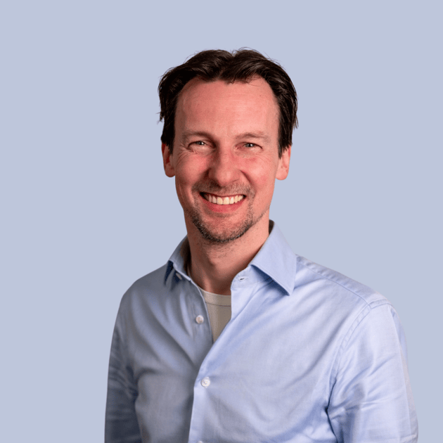 medewerker Qredits Stefan van den Brakel man in blauw shirt voor grijze achtergrond