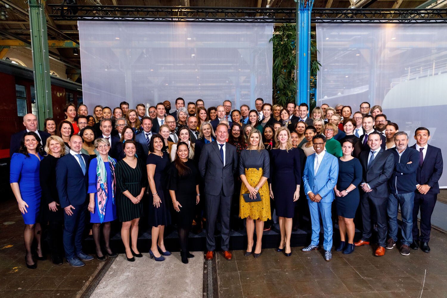 teamfoto van qredits met Koningin Maxima voor een doek