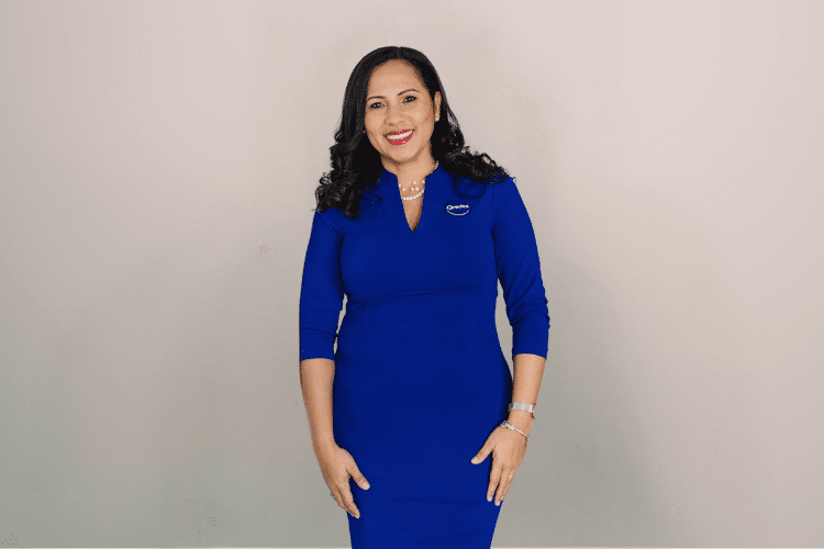 medewerker Qredits Raiska Herrera lange blauwe Qredits kleding lacht in camera