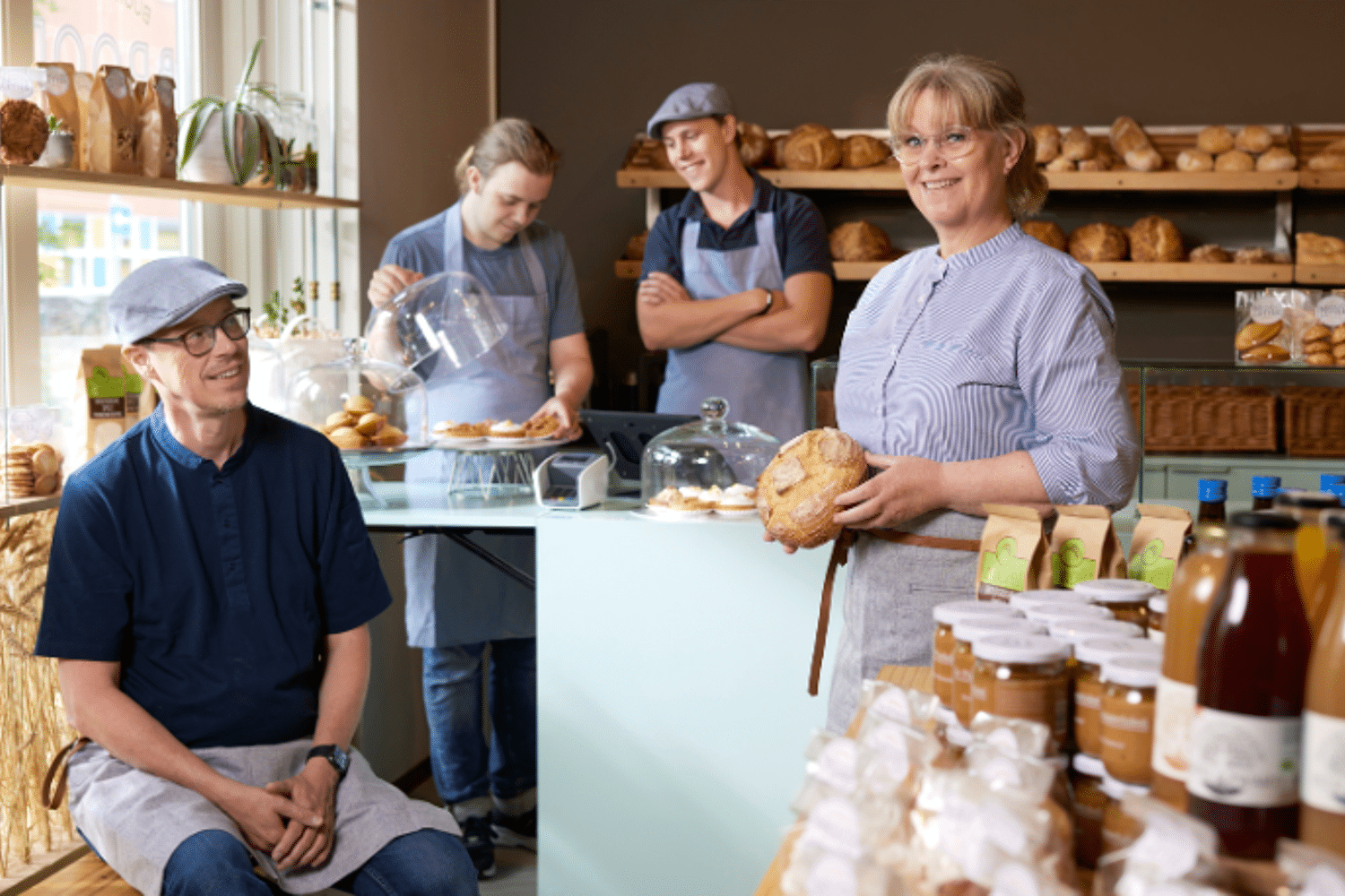 Een team staat in bakkerij en laat vers brood zien