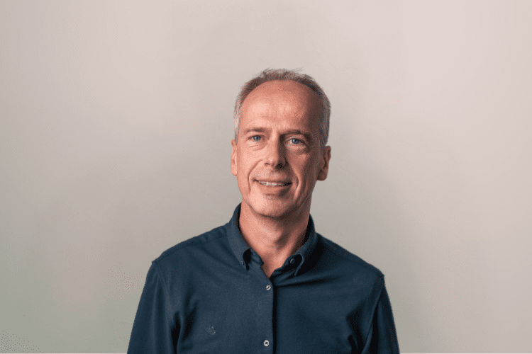 medewerker Qredits Rolf Kalksma man in donker shirt voor grijze achtergrond