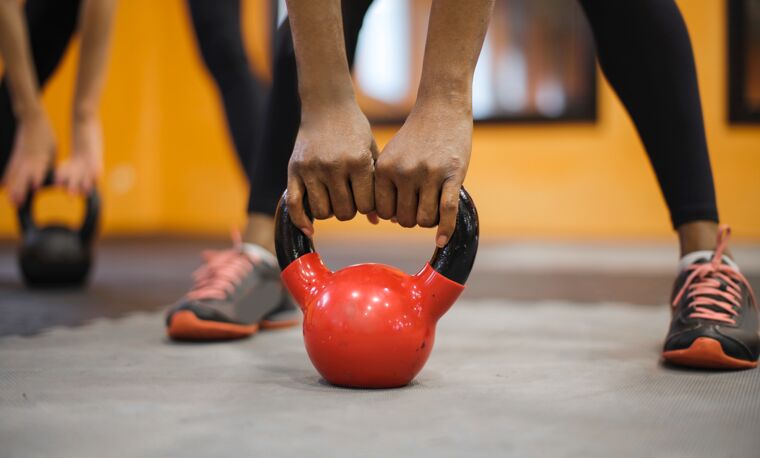 rood gewicht wordt opgetild van sport mat
