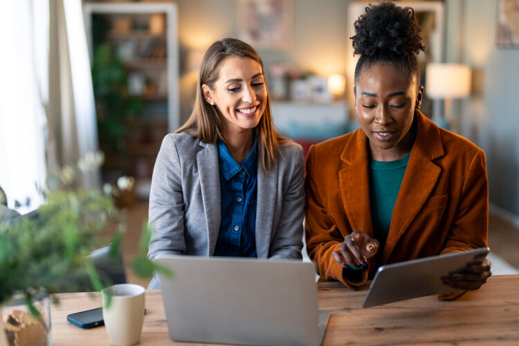 twee-vrouwen-achter-laptop-en-ipad-lachend