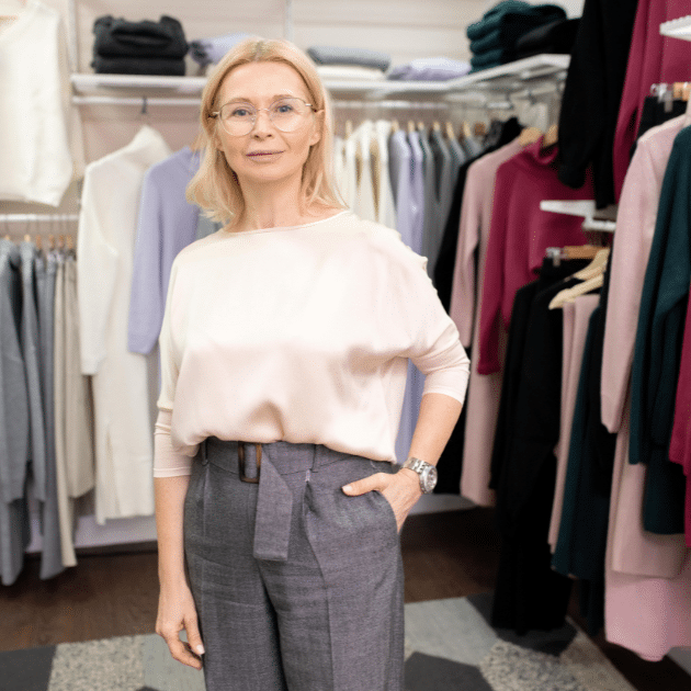 een vrouw staat midden in haar kledingzaak