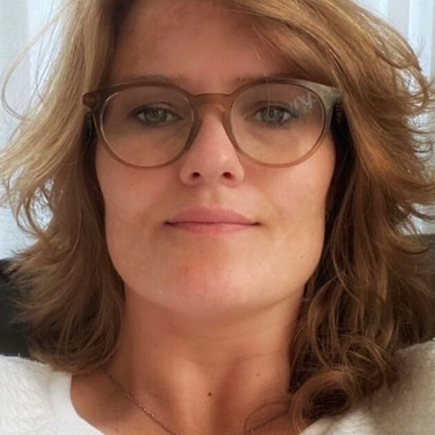 Vrouw maakt een selfie en kijkt in de camera.