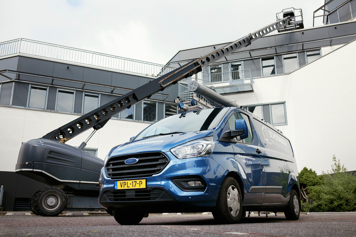 auto-busje-blauw-hijskraan busje staat voor het qredits pand