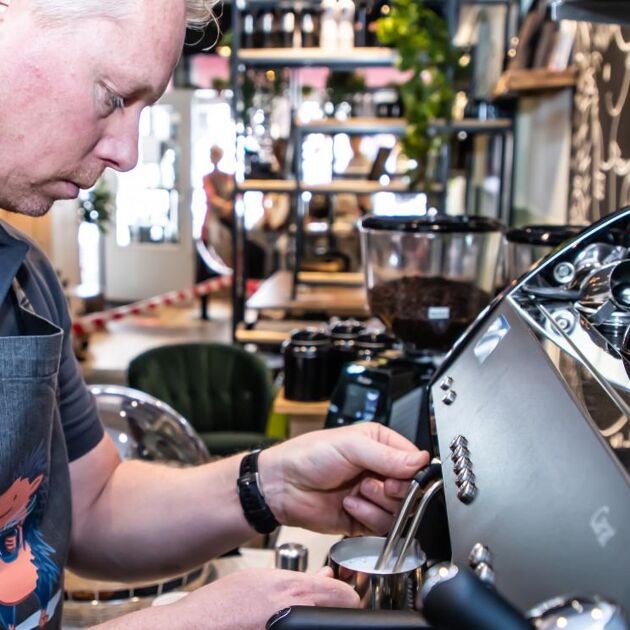 Man maakt koffie bij een koffieapparaat 