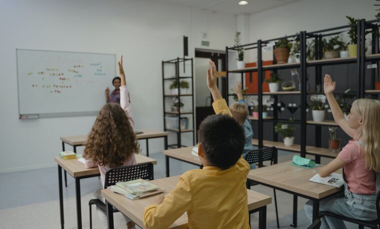 Kinderen in een klas steken vinger op