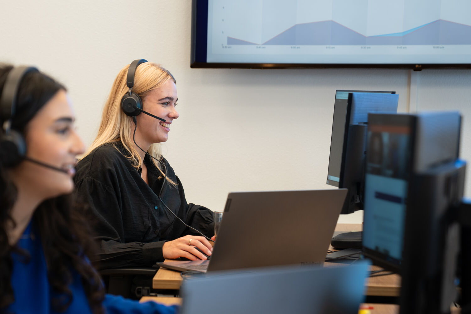 vrouwen-met-koptelefoons-werken-met-computer