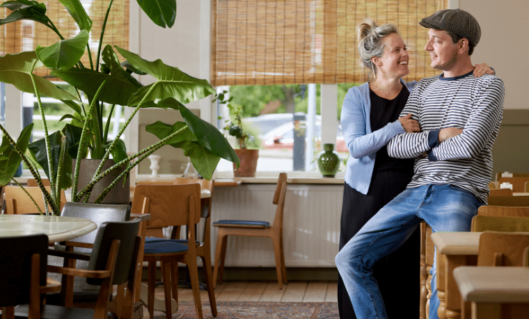 Man en vrouw kijken liefdevol naar elkaar toe in restaurant 