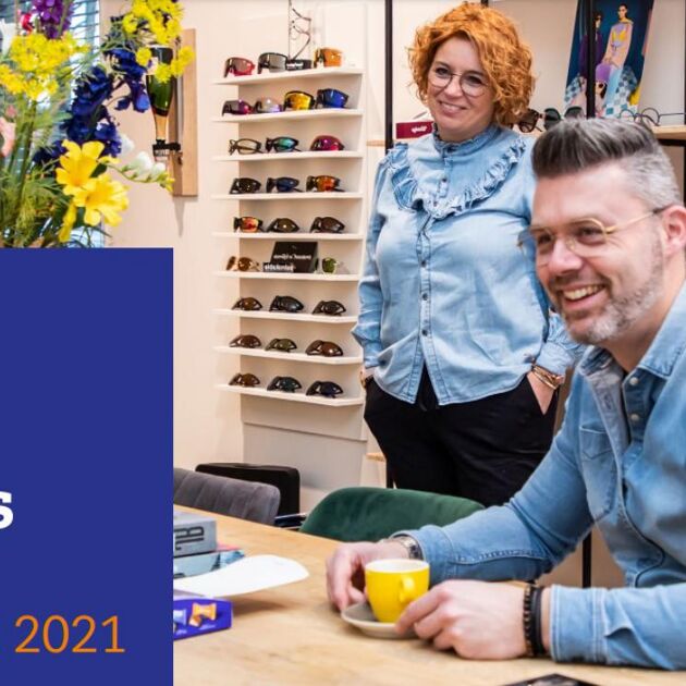 Man en vrouw zitten aan een kop koffie met op de achtergrond brillen uit hun eigen brillenzaak.