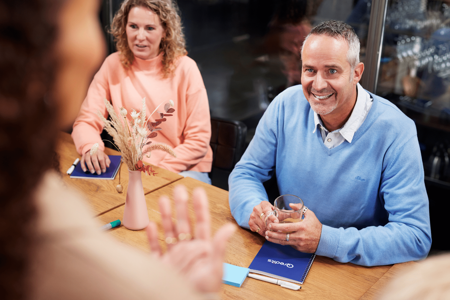 tijdens een zakelijke training lacht een man naar de qredits trainer
