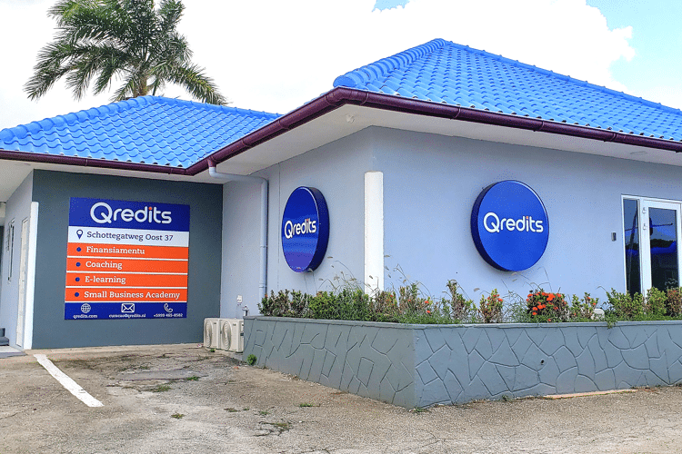 Blauw gebouw in Curacao met Qredits logos op muur