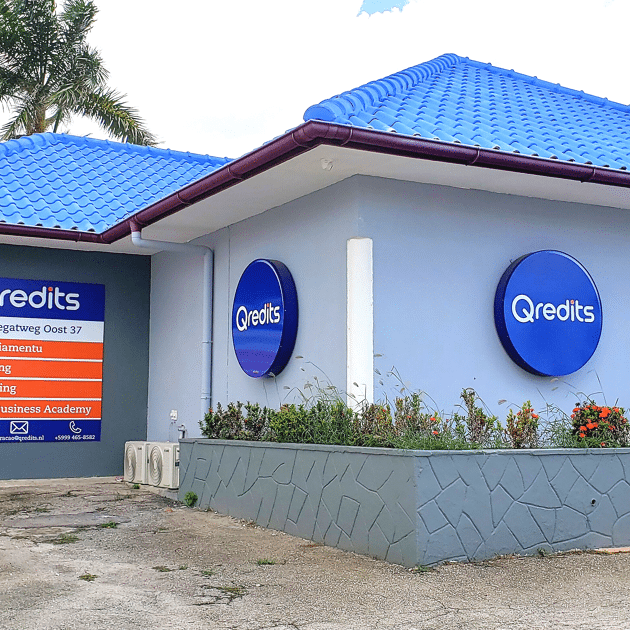 Blauw gebouw in Curacao met Qredits logos op muur