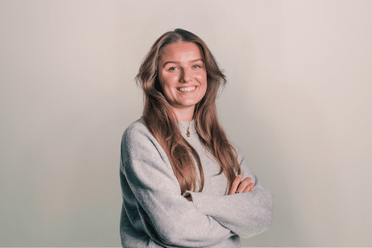 Nynke medewerker Qredits vrouw in grijs shirt voor grijze achtergrond