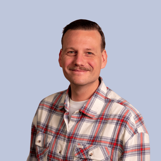 medewerker Qredits Tim Bouman grijze trui snor