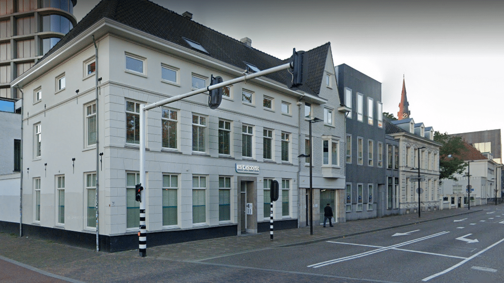 Wit gebouw aan de straat bij een stoplicht