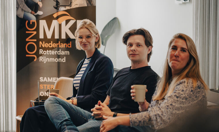 Drie jonge ondernemers luisteren tijdens een event