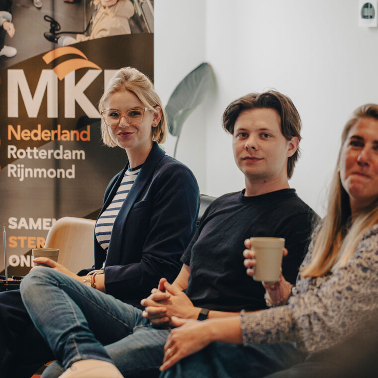 Drie jonge ondernemers luisteren tijdens een event