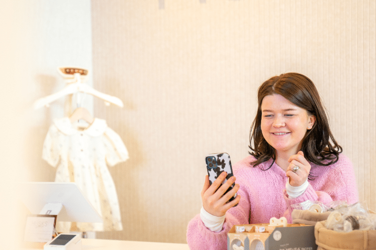 husks-vrouw-kijkt-lachend-naar-mobiel