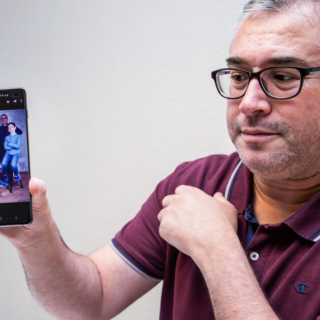 Man toont op zijn telefoon een foto van zijn gezin.
