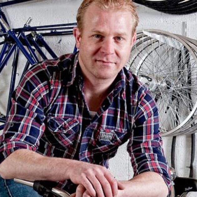 Man met meerdere fietsen op de achtergrond