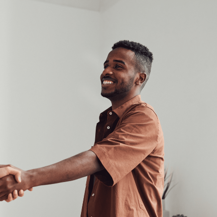 Man in bruin shirt schud hand van andere man