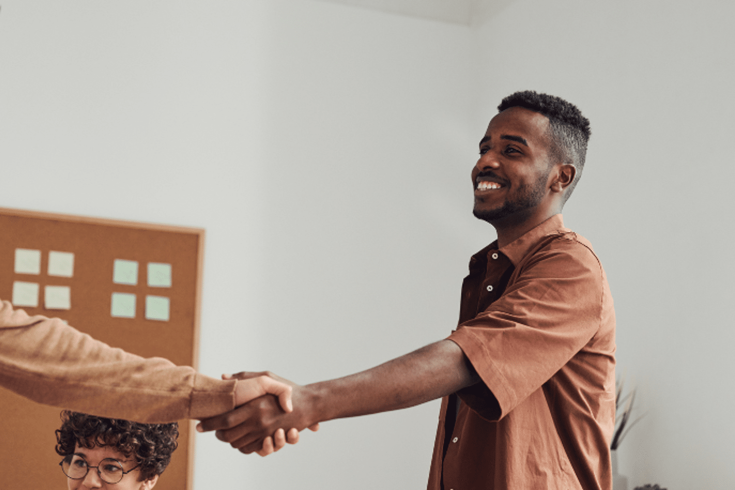 man-schudt-handen-met-andere-man-partners Man in bruin shirt schud hand van andere man