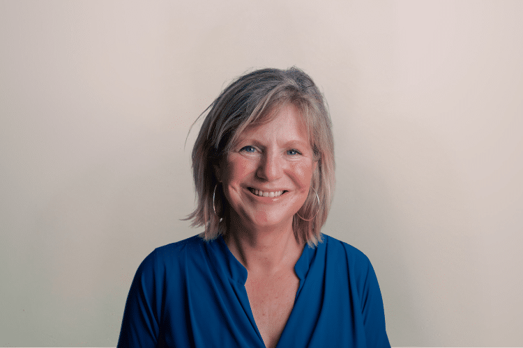 Marleen medewerker Qredits vrouw in blauw shirt voor grijze achtergrond