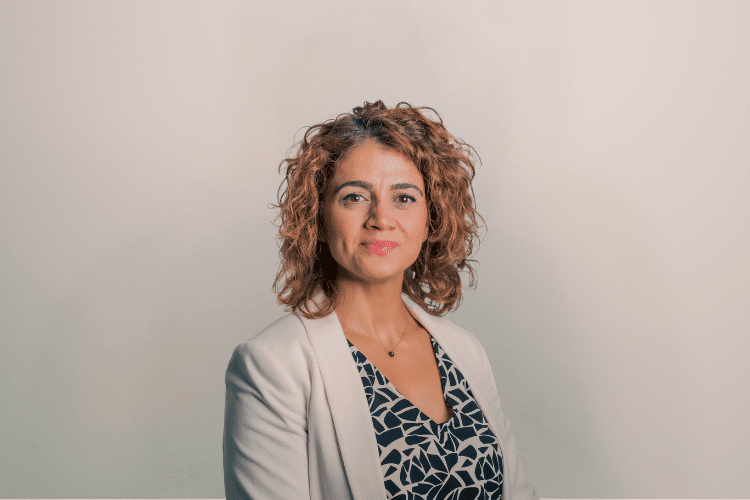 Nouna medewerker Qredits vrouw in wit jasje voor grijze achtergrond
